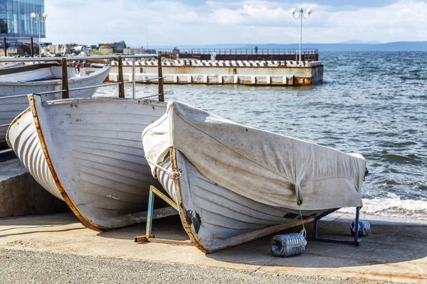 Vecchie barche in legno sulla riva sul lungomare della città . — Foto Stock