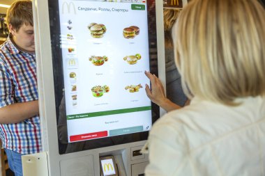 Moskova, Rusya, 08/11/2019: Bir kadın elektronik menüde Mcdonald's'ta yemek seçiyor.