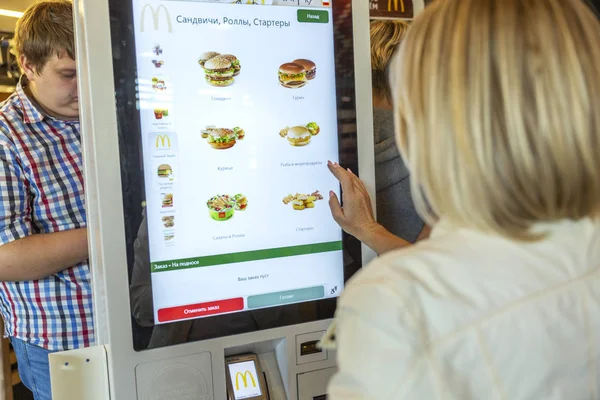 Moscú, Rusia, 08 / 11 / 2019: Una mujer elige comida en McDonald 's en el menú electrónico . — Foto de Stock