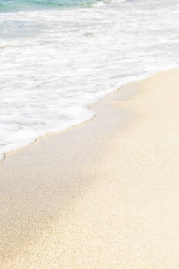 Kumlu sahilde yumuşak köpüklü dalga. Arka plan, metin alanı. 