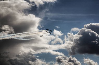 Military aircraft swift in the sky. Demonstration of technology at the festival. Gloomy cloudy sky. clipart