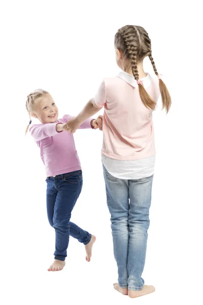 Dziewczynki dziewczyny w dżinsy i różowe swetry trzymać ręce i śmiech. Czułość i przyjaźń. Izolowane na białym tle. — Zdjęcie stockowe