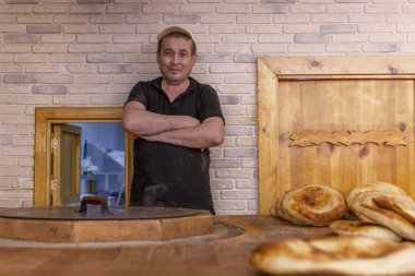 Moskova, Rusya, 07.24.2019: Gülümseyen erkek fırıncı bir süpermarkette oryantal kek pişirir.