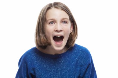 Mavi kazak lı sevimli bir genç kız duygusal olarak bağırır. Beyaz arka plan üzerinde yalıtılmış.