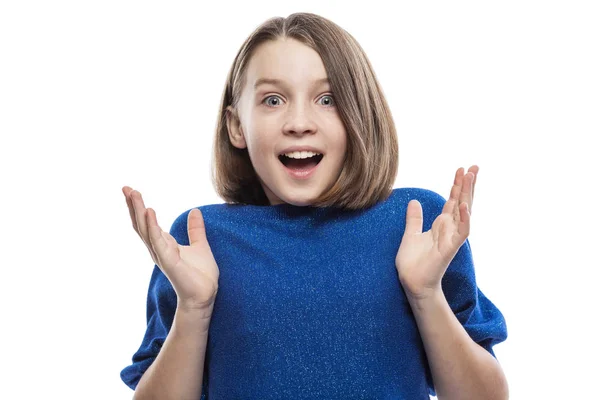 Una ragazza carina adolescente in un maglione blu è piacevolmente sorpresa. Forti emozioni positive. isolato su sfondo bianco . — Foto Stock