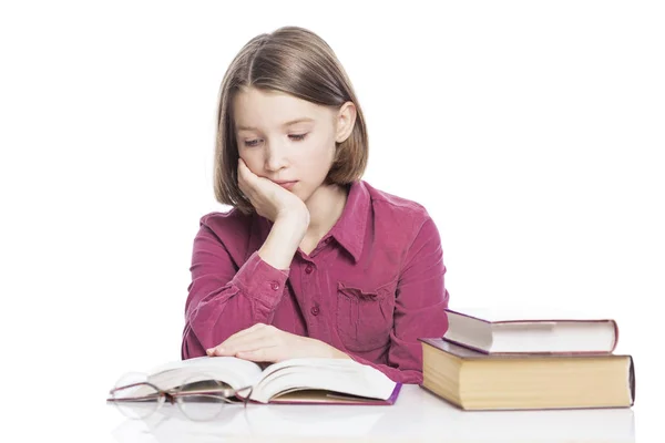 Ein müdes Teenie-Mädchen sitzt an einem Tisch mit Büchern. isoliert über weißem Hintergrund. — Stockfoto