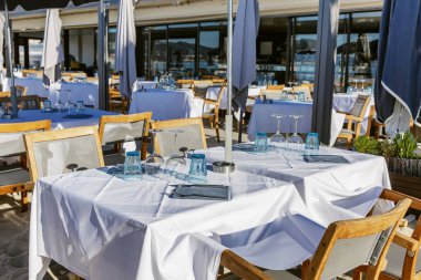 Açık güneşli bir günde açık restoran masaları. Kumsaldaki kafe..