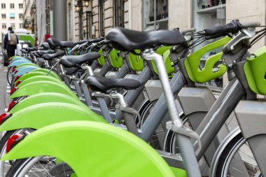 Bir sıra park edilmiş şehir bisikleti. Çevre dostu lekeli spor. Yakın plan..