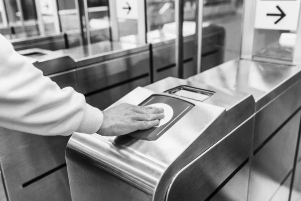 Torniquete en el metro. Un hombre aplica un billete y va a los trenes. Primer plano. Blanco y negro . — Foto de Stock