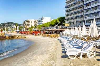 Juan Le Pen, Fransa, 10 / 06 / 2019: Güneşli bir günde deniz kenarında şemsiyeli güneş panzeleri. Rahatla ve sakinleş. Metin için boşluk.