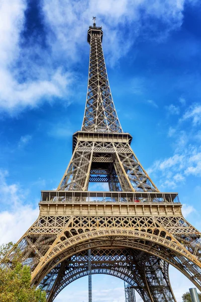 Eiffeltornet i den gröna av träden mot den blå himlen på en ljus solig dag. — Stockfoto