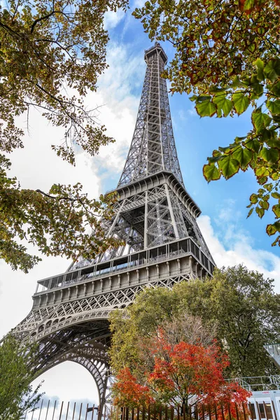 Eiffel-torony a fák zöldjében a kék ég ellen egy fényes, napos őszi napon. — Stock Fotó