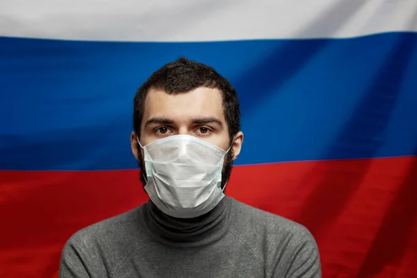 Młody Człowiek Masce Medycznej Tle Rosyjskiej Flagi Niepokój Przyszłość Zbliżenie — Zdjęcie stockowe