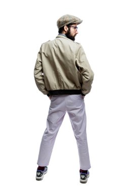 Gözlüklü, sakallı ve şapkalı şık bir genç. Arkadan bak. Beyaz bir arka planda izole edilmiş. Dikey.