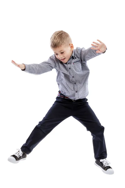 一个穿着牛仔裤和衬衫的小男孩跳了起来 被白色的背景隔离了垂直方向 — 图库照片