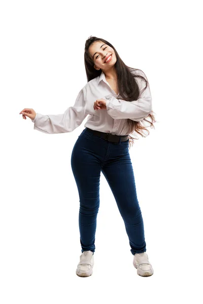 一个穿着牛仔裤和白衬衫的小女孩笑着跳舞 留长发的布鲁内特积极和感情 被白色的背景隔离了垂直方向 — 图库照片