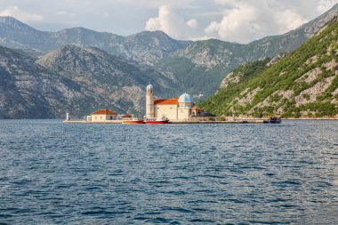 Kotor 'daki dağların arka planına karşı denizde bir kilisesi olan bir ada. Güzel manzara.
