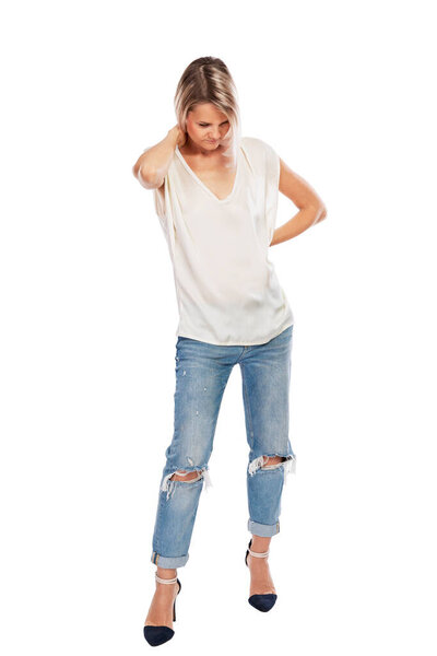 The young blonde in jeans and a white T-shirt thought about it, head down. Isolated on a white background. Full height. Vertical.