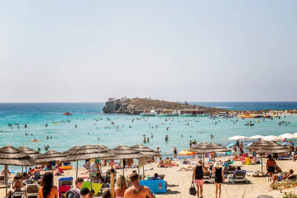 Ayia Napa, Kıbrıs Rum Kesimi 09 / 02 / 2018: Tatilcilerle dolu plaj. Turkuaz deniz güneşli bir günde.