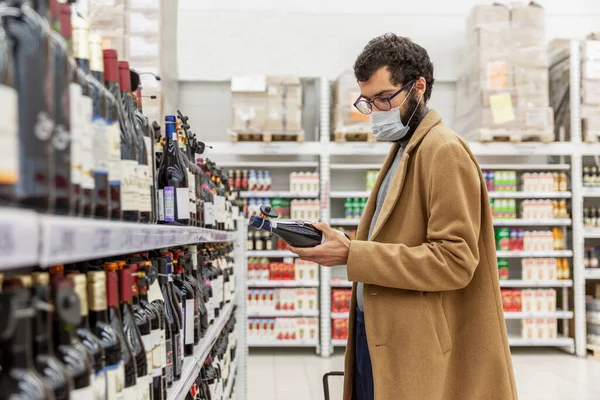 Jovem Num Supermercado Escolhe Álcool Secção Vinhos Uma Morena Casaco — Fotografia de Stock