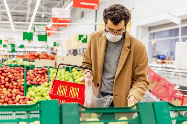 Jovem Com Uma Máscara Médica Está Escolhendo Frutas Grande Supermercado — Fotografia de Stock