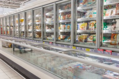 Büyük bir süpermarkette dondurulmuş yiyeceklerin olduğu cam vitrinler. Bulanık.