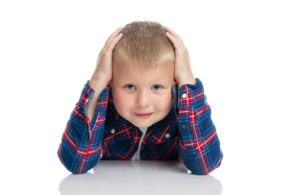 Een Leuke Schooljongen Zit Aan Tafel Houdt Zijn Hoofd Met — Stockfoto