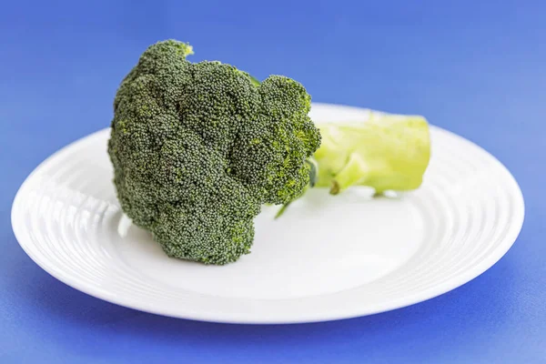 Cabeça Suculenta Brócolis Uma Chapa Branca Fundo Azul Close Alimentos — Fotografia de Stock