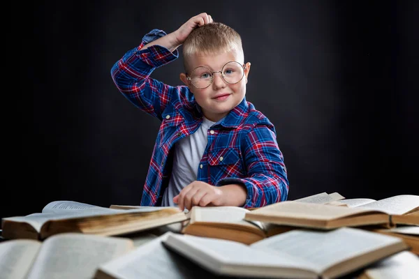 Szemüveges Iskolás Fiú Egy Asztalnál Egy Halom Könyvvel Képzés Tudás — Stock Fotó
