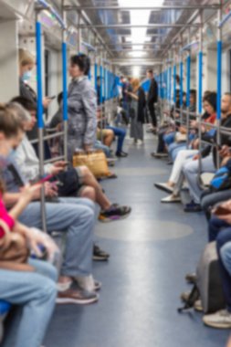 İnsanlar bir metro vagonunda durup oturuyorlar. Dikey. Bulanık.