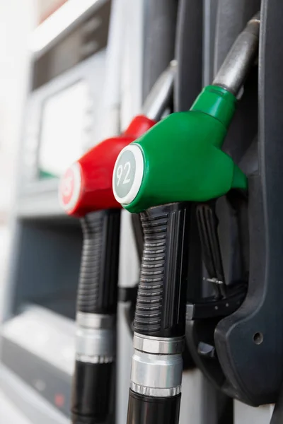 Pistols with gasoline at the gas station. Close-up. Vertical.