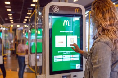 İnternetten McDonald 's servisi içeride. Kız ekrana dokunarak sipariş veriyor. Moskova, Rusya, 08 / 25 / 2020.