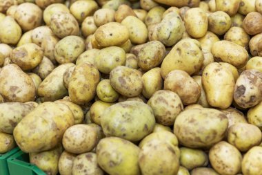 Süpermarketin sebze reyonundaki tezgahta patates var. Yakın plan. Arkaplan.