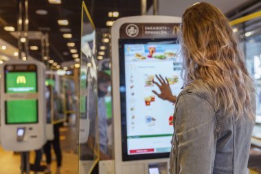 McDonald 's' daki genç sarışın kadın internetten sipariş veriyor. Moskova, Rusya, 09 / 21 / 2020.