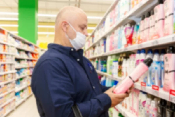 Человек Маске Супермаркете Выбирает Чистящее Средство Пандемия Коронавируса Размытый — стоковое фото