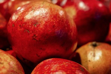 Tezgahta bir sürü parlak sulu nar var. Mevsimlik meyveler. Sağlıklı beslenme ve vejetaryenlik. Yakın plan..