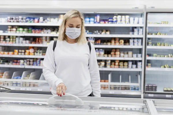 Молодая Блондинка Медицинской Маске Выбирает Замороженные Продукты Большом Супермаркете Здоровое — стоковое фото