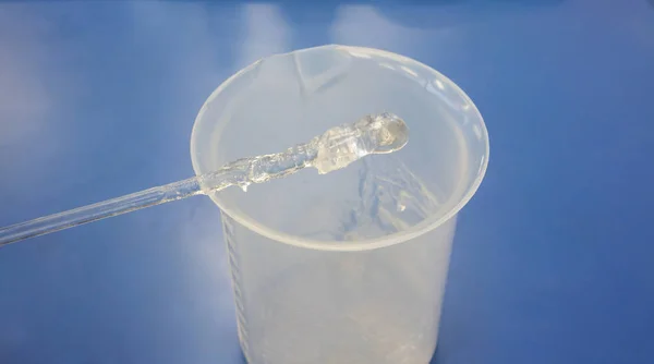 ガラス攪拌プラスチック ビーカーの上に粘度の高い透明な溶液で引けた ゲルの Diy の手消毒剤ゲルを形成するステップ — ストック写真