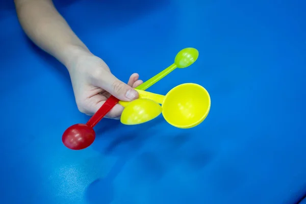 Girl Presenting Measuring Spoon Set Red Yellow Colors Blue Table — Stock Photo, Image