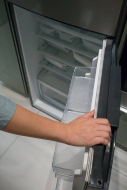 Tek renkli buzdolabının kapısını gümüş renk tanıtıcısı açılış eller yukarıda kapalı.