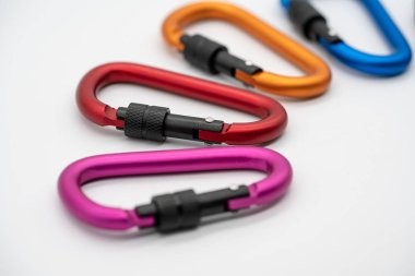 Beyaz arka plan üzerinde izole renkli mat metal alüminyum ek kanca. Emniyet kilidi çantanıza halat tırmanma için