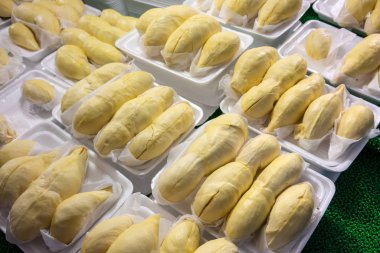 Satılık ekranda beyaz köpük tabak içinde durian meyve parçaları. Sarı taze yakın durain meyve Tayland Kralı olduğunu.