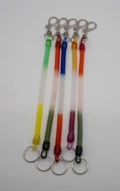 Beyaz arka plan üzerinde izole strecthable sarmal dize ile renkli Anahtarlık yüzük ve gümüş metal kanca.