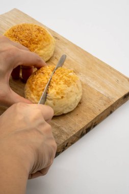 El kesme bütün topuz ile susam beyaz arka plan üzerinde izole ahşap kare kesme tahtası üzerinde.