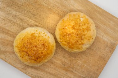 Beyaz arka plan üzerinde izole ahşap kare kesme tahtası üzerinde susam ile iki bütün buns.