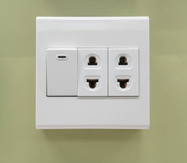 Elektrik anahtarı ve ışık yeşil duvar üzerinde yüklü fiş