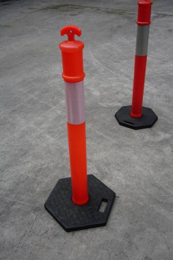 Beton yol üzerinde trafik için beyaz şerit çizgileri ile turuncu plastik direkleri