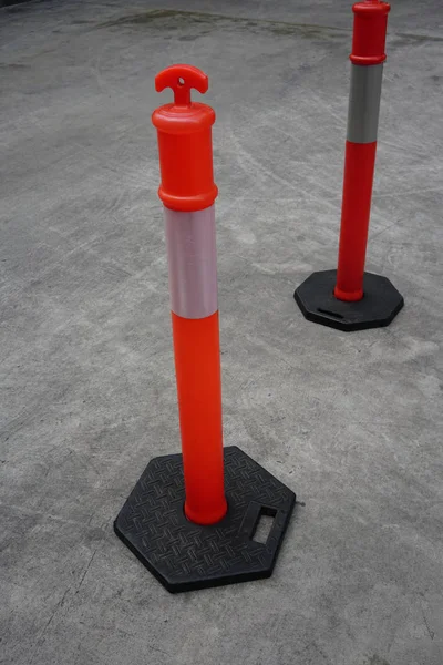 Beton yol üzerinde trafik için beyaz şerit çizgileri ile turuncu plastik direkleri