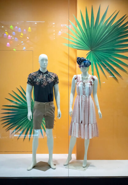 Xact store at Central Rama 9, Bangkok, Thailand, Apr 30, 2018 : Fashionable brand window display. Standing couple in beach outfits against yellow background with palm leaf.