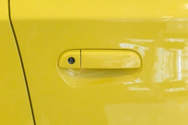 Yellow car door handle. Car exterior detail for modern car